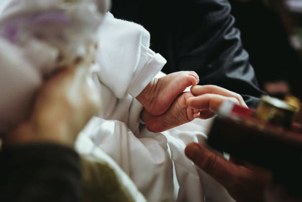christening of little baby in church, close-up feet and priest hand christening of little baby in church, close-up feet and priest hand baptism photos stock pictures, royalty-free photos & images