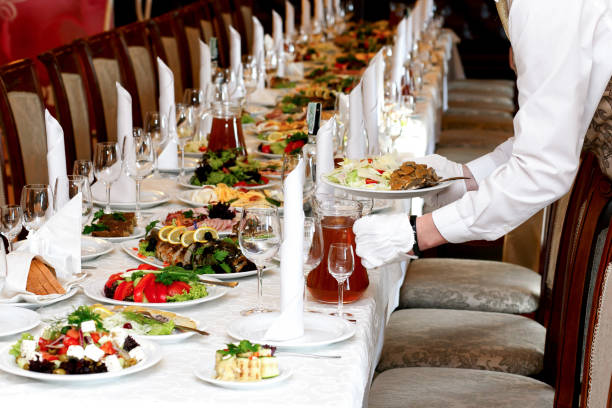 cameriere che serve cibo al tavolo di lusso allestito al ricevimento di nozze, catering al ristorante - restaurant banquet table wedding reception foto e immagini stock