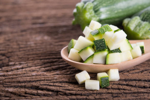 istock whole and cube cut fresh zucchini on wooden background 948570678