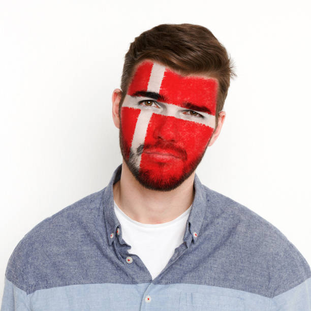istock Young man with Denmark flag painted on his face 948570838