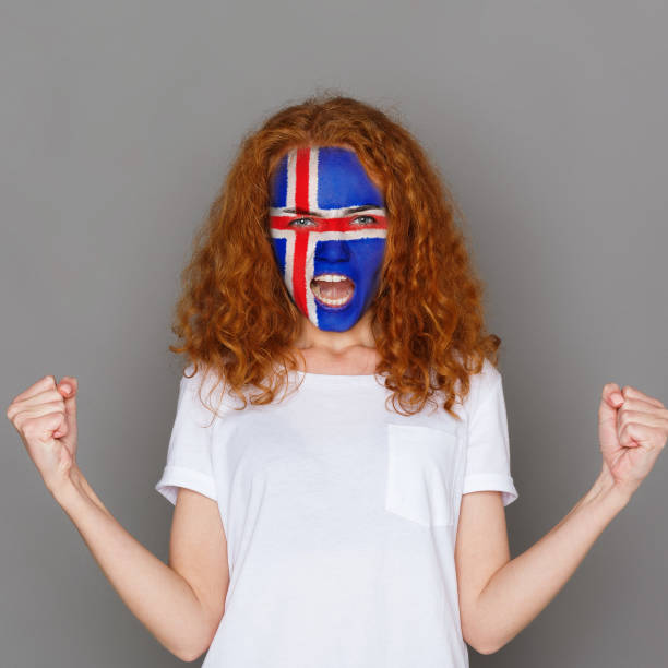 istock Young woman with Iceland flag painted on her face 948570932