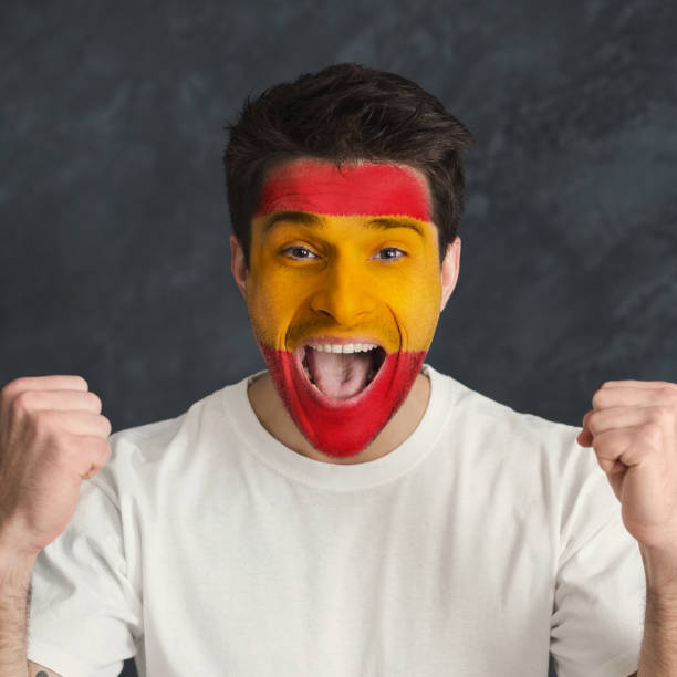istock Young man with Spain flag painted on his face 948571026