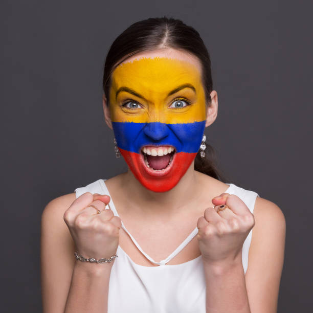istock Young woman with Columbia flag painted on her face 948571106