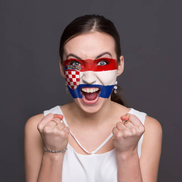 istock Young woman with Croatia flag painted on her face 948571972