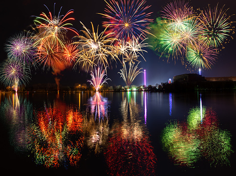 Multiple fireworks with reflections over lake Dutzendteich at spring fair in Nuremberg