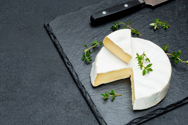istock Camembert cheese and cut a slice on stone serving board 948575236