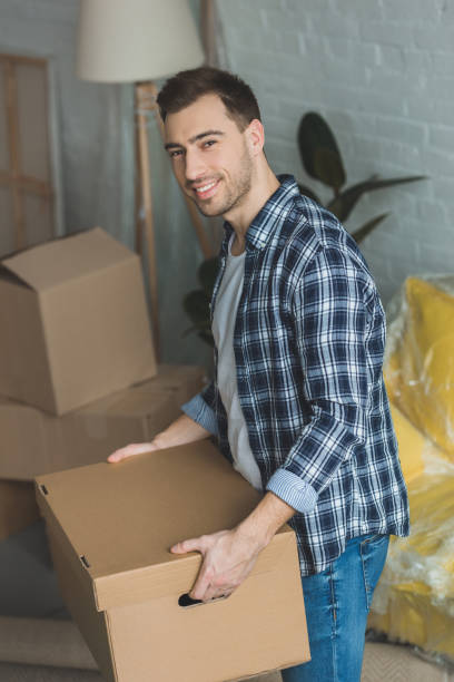 istock smiling man with cardboard box in hands at new home, relocation concept 948575834