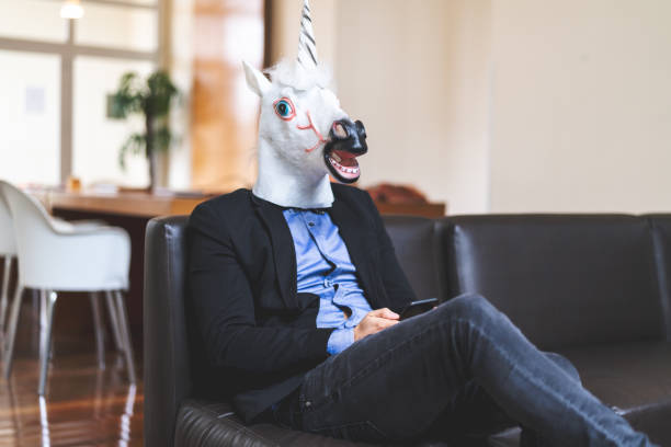 istock Business man with Unicorn Mask Using Mobile at Office 948577774