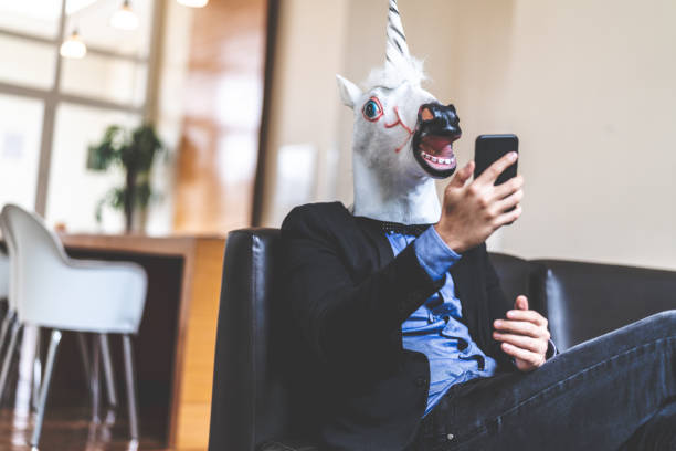 istock Business man with Unicorn Mask Taking a Selfie at Office 948577782