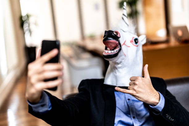 istock Business man with Unicorn Mask Taking a Selfie at Office 948588202