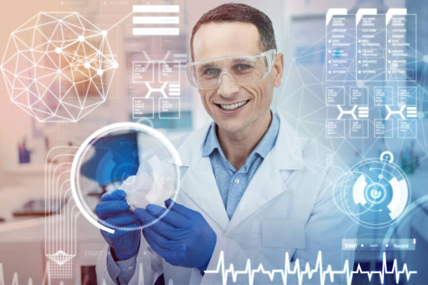 istock Cheerful doctor smiling and using futuristic technologies in his work 948588324