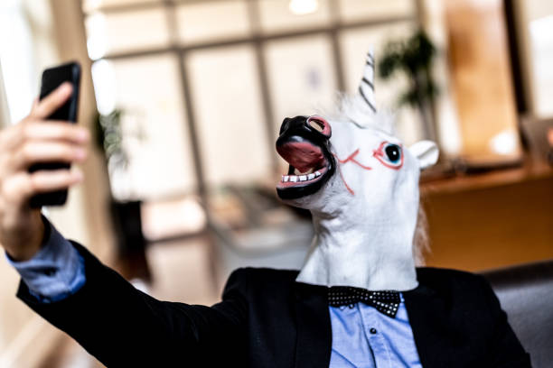 istock Business man with Unicorn Mask Taking a Selfie at Office 948588362
