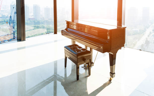 Black piano in front of a window