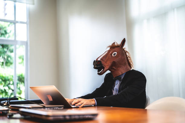 uomo d'affari con maschera da cavallo che lavora in ufficio - horse men animal head bizarre foto e immagini stock
