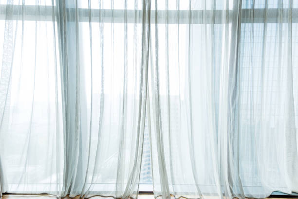 белый занавес висит в окне - translucent стоковые фото и изображения