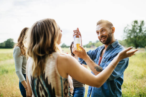 istock Man Presenting Wine To Friends At Lunch Meetup 948594184