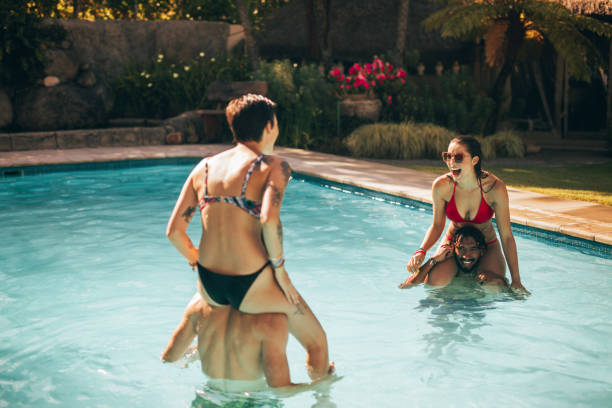 istock Group of friends having fun in the pool 948600584