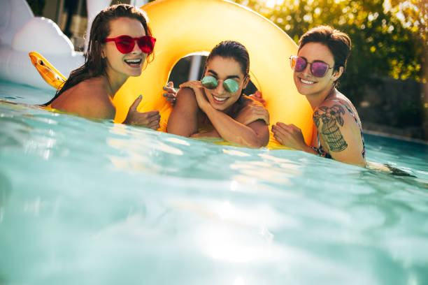 istock Female friends having fun in a swimming pool 948601024
