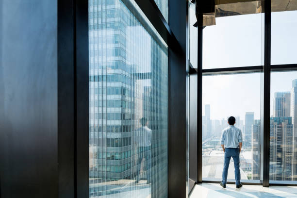 istock Businessman standing and looking at cityscape 948601088