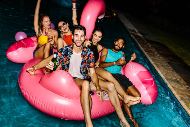 istock Friends hanging out at evening pool party 948601092