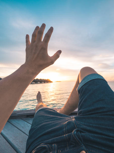 istock Young Man Watching the Sunset in Maldives 948603116