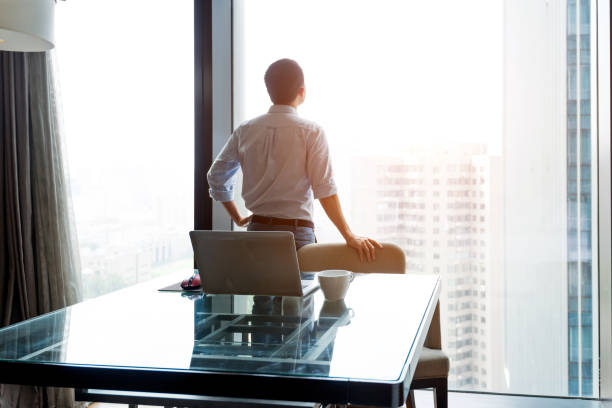 istock Businessman standing and looking at cityscape 948603676