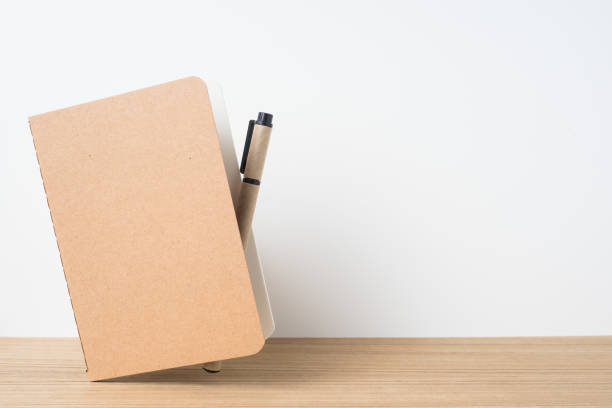 istock front view of floating kraft notebook and  on wooden desktop and white background for mockup 948605868