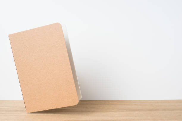 istock front view of floating kraft notebook and  on wooden desktop and white background for mockup 948605970