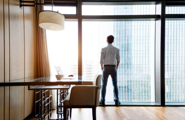 istock Businessman standing and looking out the window 948606002