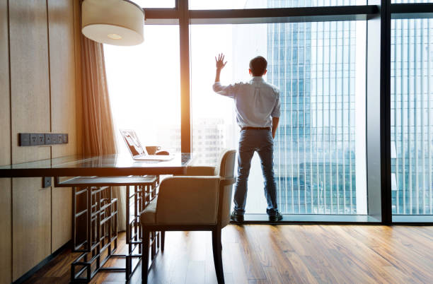 istock Businessman standing and looking out the window 948606016