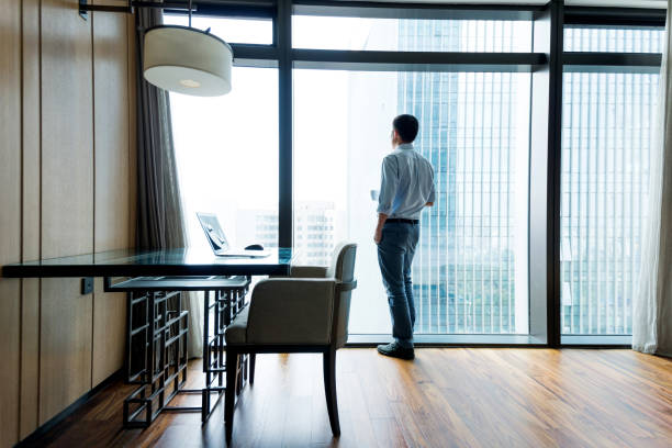 istock Businessman standing by the window to rest 948606556