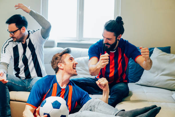 istock Two happy and one displeased soccer enthusiasts 948609800