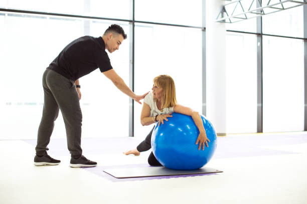 istock Senior woman exercise with personal coach 948610372