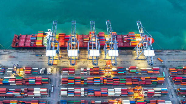 istock Container ship in export and import business and logistics. Shipping cargo to harbor by crane. Water transport International. Aerial view and top view. 948614258