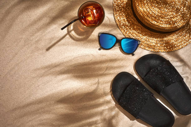 istock Sandal, straw hat and sunglasses on a sandy background, top view 948617056