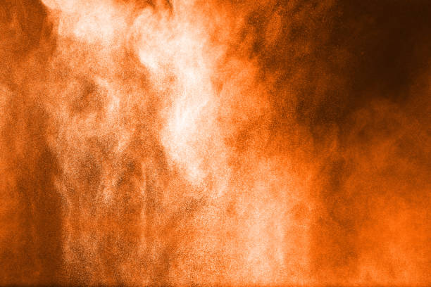 istock abstract orange dust explosion on  black background. abstract orange powder splattered on dark background, Freeze motion of orange powder splash. Painted Holi in festival. 948617160