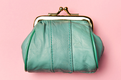 Purse for coins.Wallet for change. Leather purse, purse on a pink background. Color of the trend.The concept of poverty