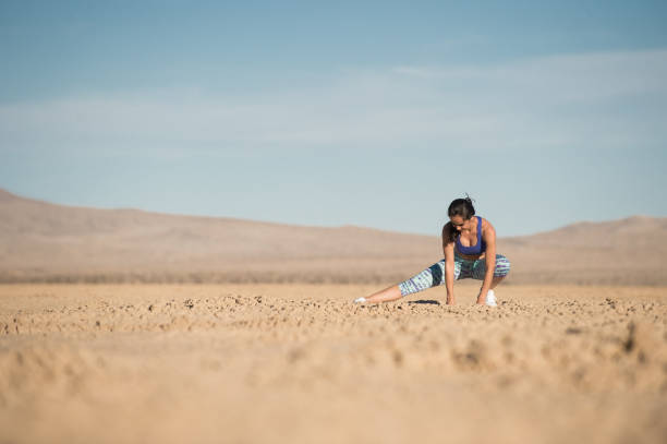 istock Female Runner Stretching In The Desert 948624152