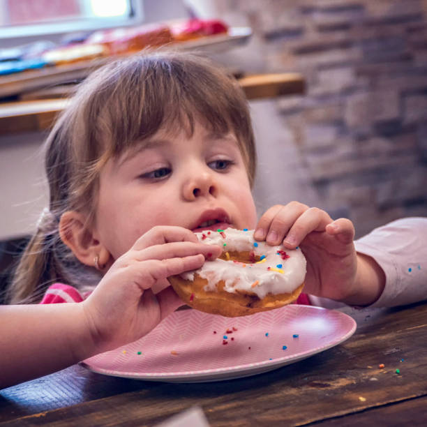istock Kids Eating Donuts with Icing and Chocolate 948625004
