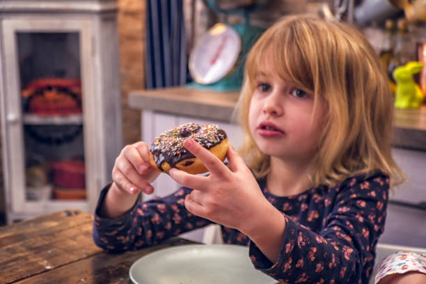 istock Kids Eating Donuts with Icing and Chocolate 948625018
