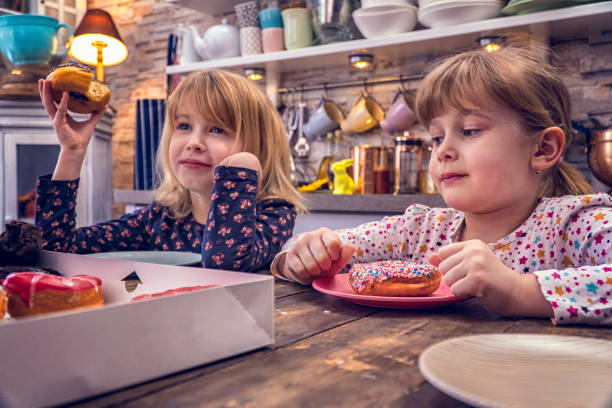 istock Kids Eating Donuts with Icing and Chocolate 948625020