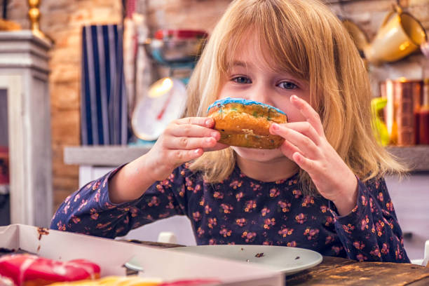 istock Kids Eating Donuts with Icing and Chocolate 948625024