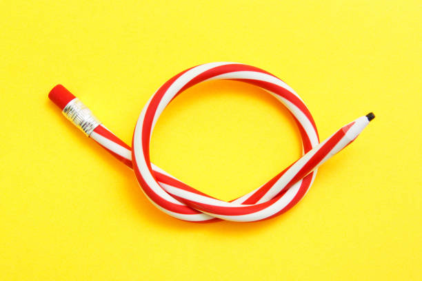 istock Flexible pencil on a yellow background. Bent pencils two-color 948627960
