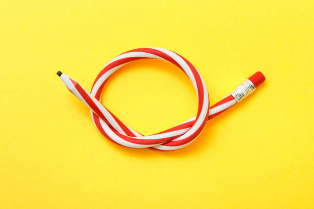 istock Flexible pencil on a yellow background. Bent pencils two-color 948628074