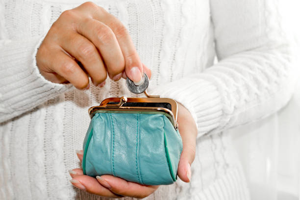 putting coin in purse. leather purse for coins.  wallet in hand . poverty - british currency currency uk coin imagens e fotografias de stock