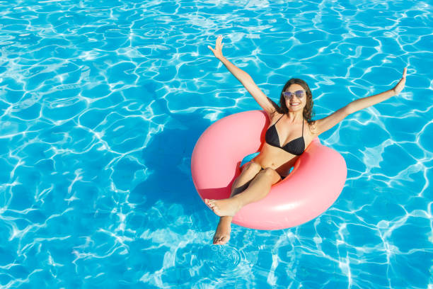 istock bikini girl with sunglasses relaxed on pink inflatable pool ring 948632318