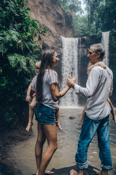 istock Family with two little  daughters  resting  near  waterfall in Bali 948643228