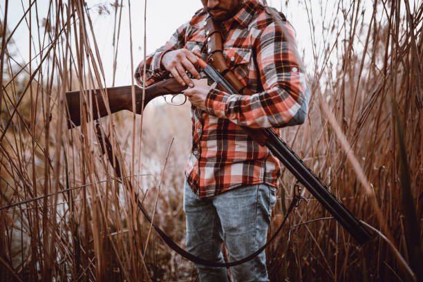 istock Hunter Putting Bullets in his Gun and Preparing for Hunting 948643578
