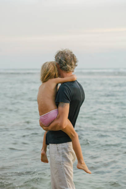 istock Father with daughter  walking on the beach in Bali 948646624