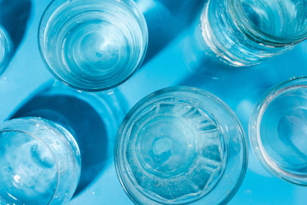 istock Flatlay arrangement with sparkling water in various glasses , summer drink concept. Top view, Blue background, selective focus 948648286